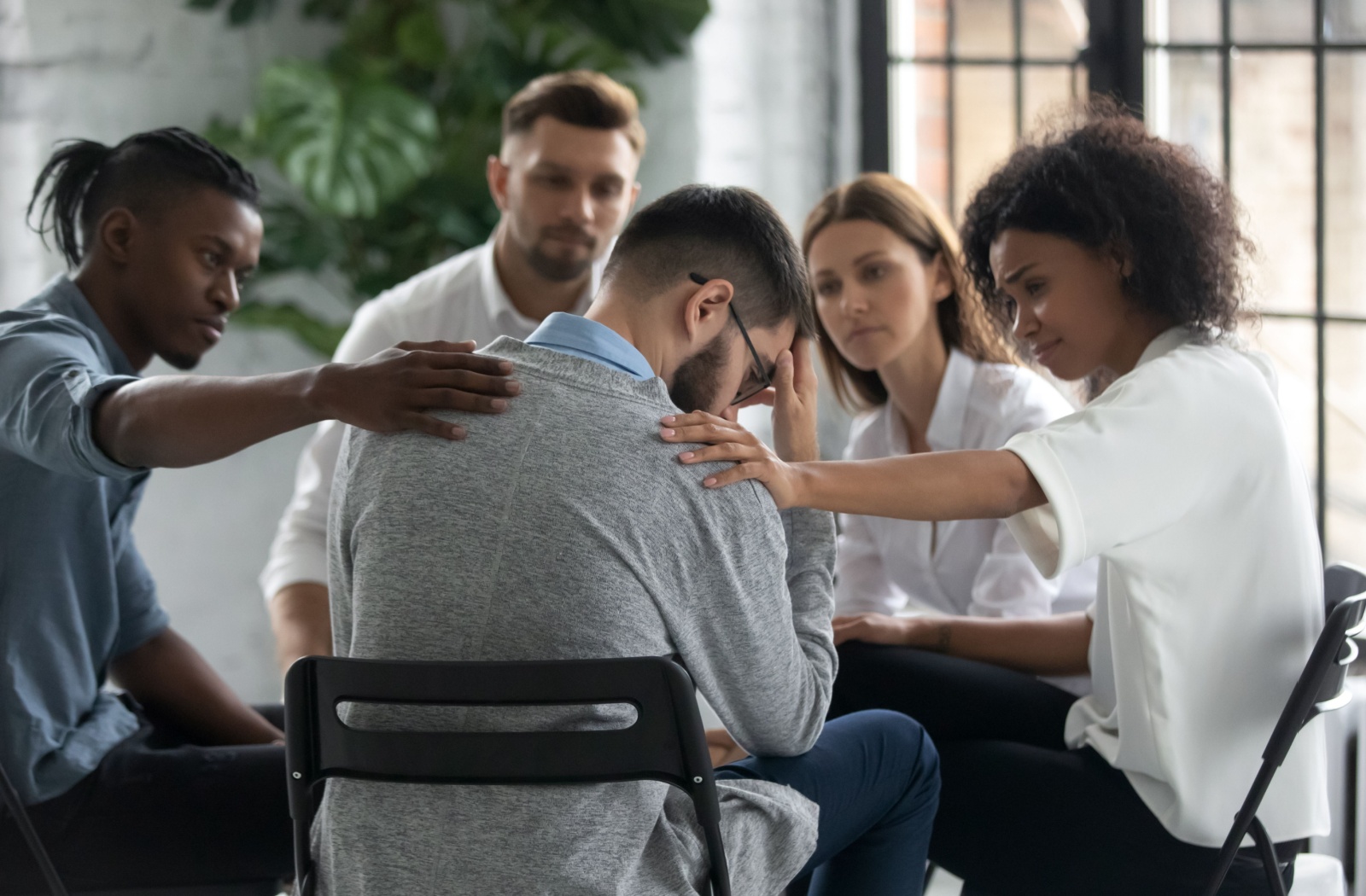 A diverse group of people sitting in a support group circle.