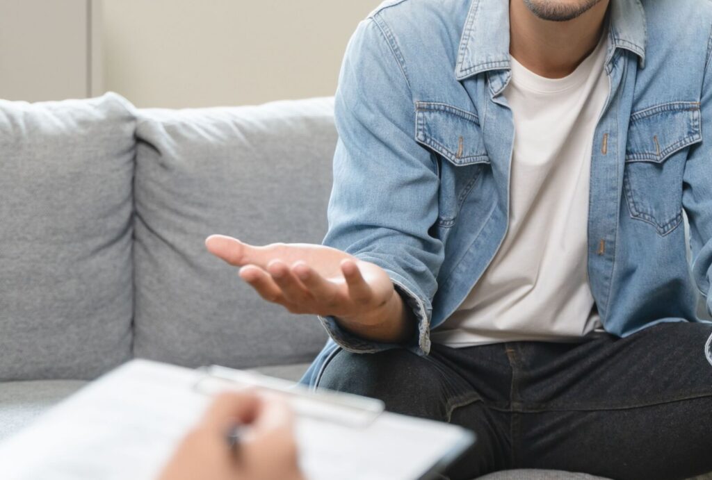 A person sitting on the couch talking to their therapist in individual addiction recovery therapy