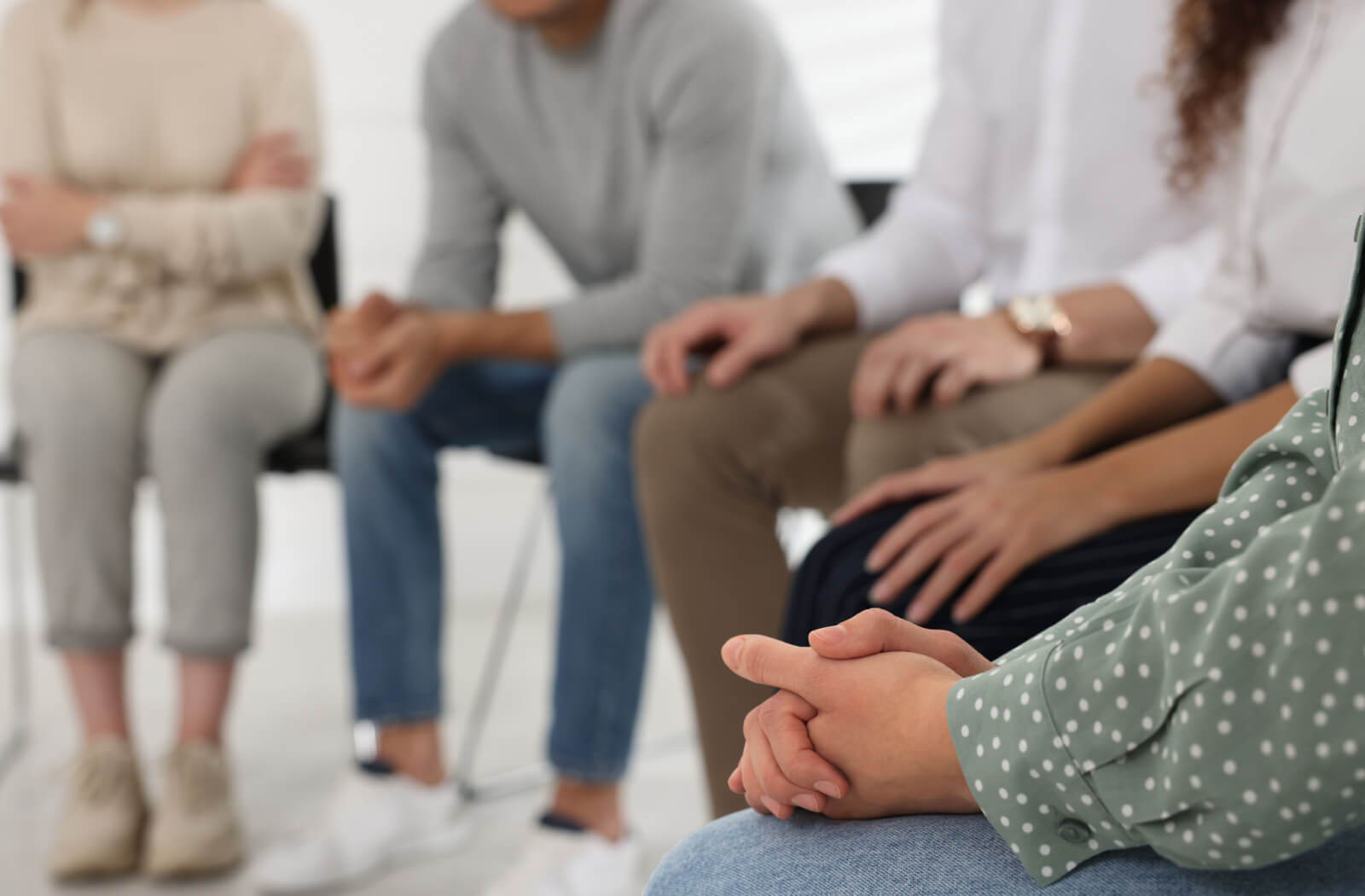 Several people sitting in a circle in support during a group therapy session in rehab.