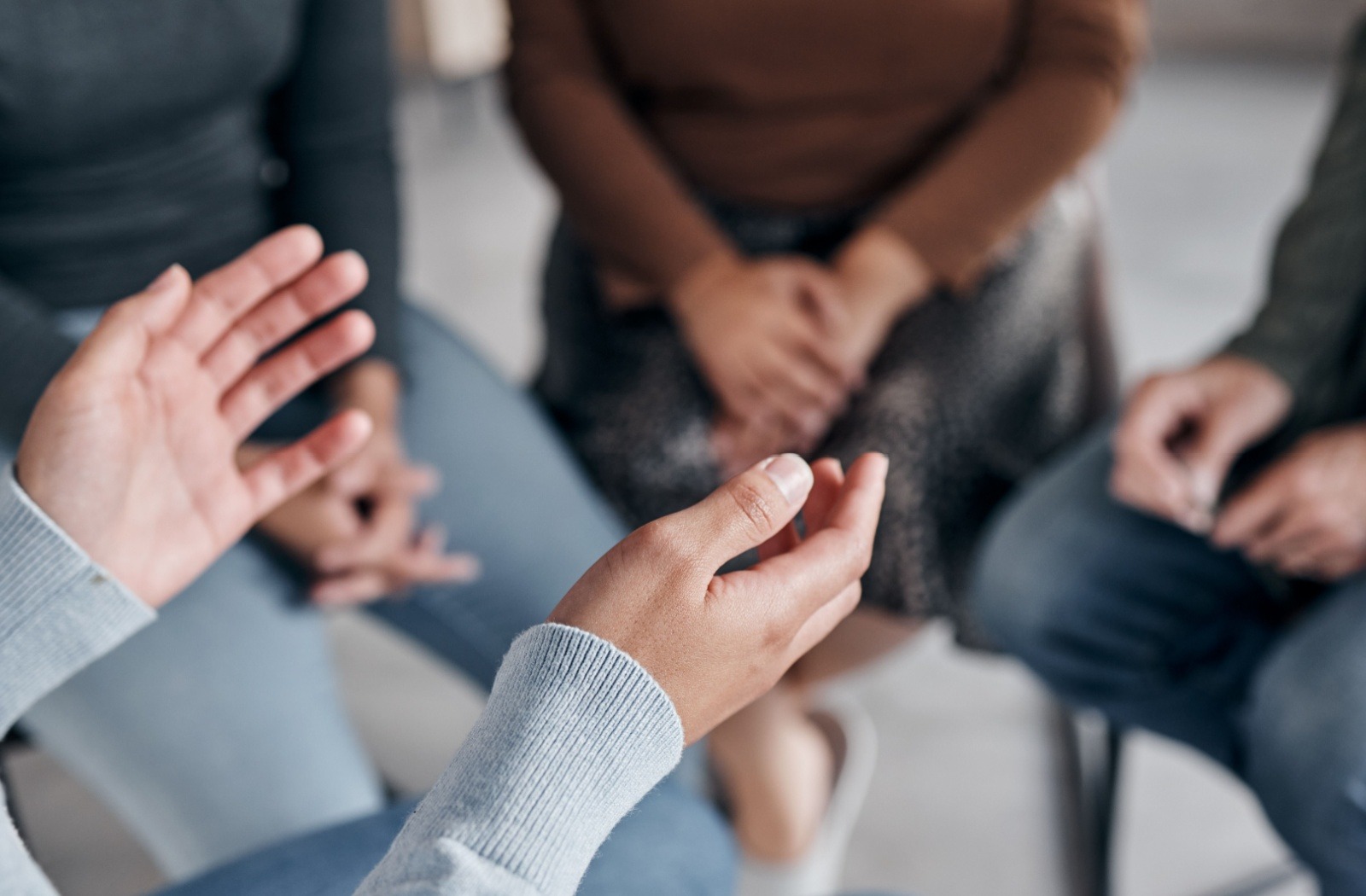 A group of people speaking together about substance use and mental health in a therapy group.